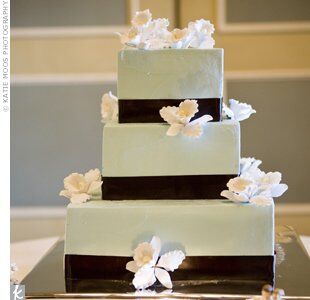 Rachel and Barry’s three-tiered, pale-blue, buttercream-frosted cake was decorated with white sugar orchids and chocolate-brown ribbon.