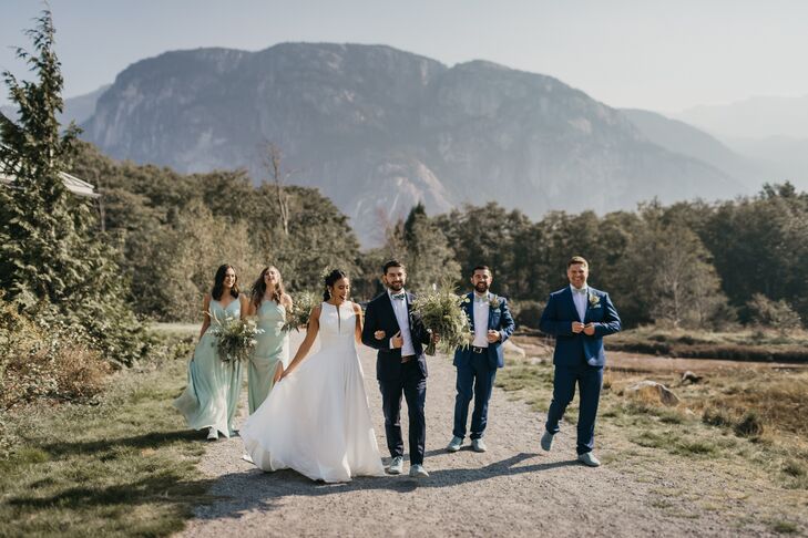 The Newlyweds and Their Wedding Party In Front of Mountains