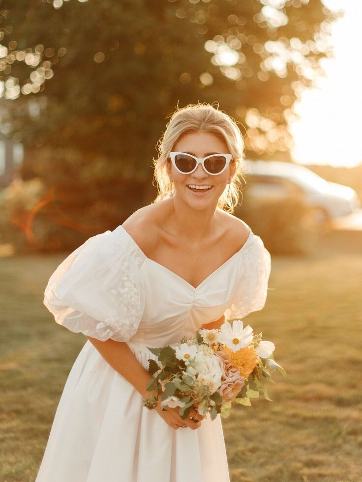 Bride wearing sunglasses and holding bouquet