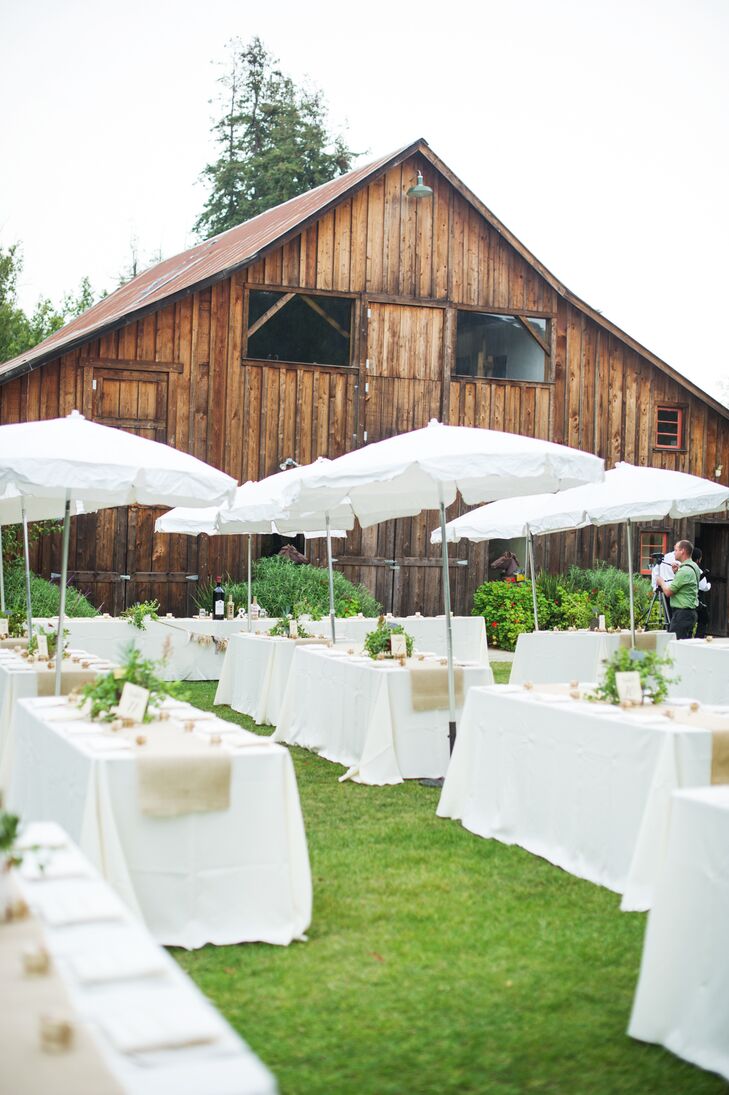Crisp white tablecloths and umbrellas cover communal dining tables at the reception, which took place adjacent to the ceremony site.