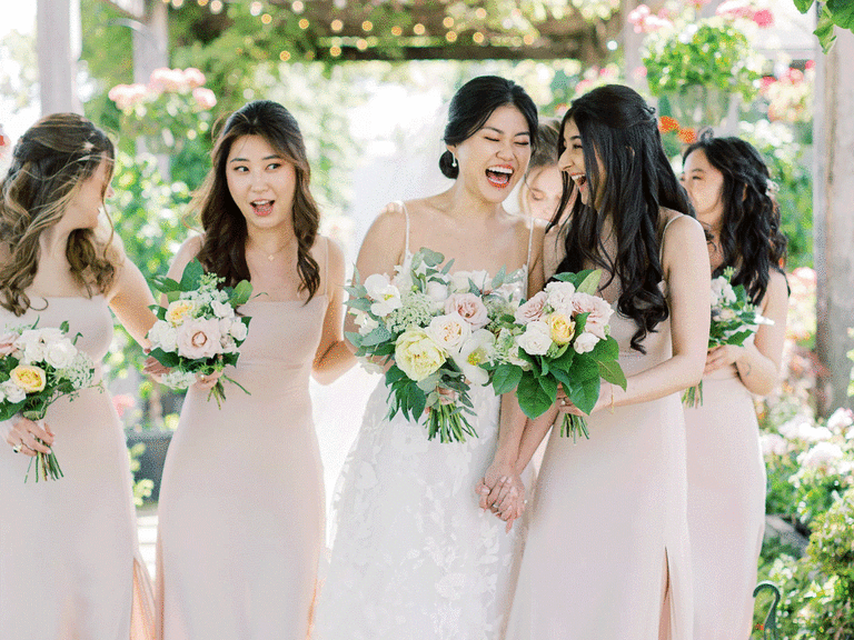 Bride and bridesmaids laughing together.