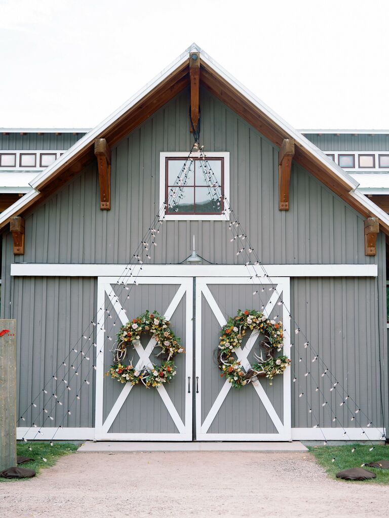 exterior of barn wedding venue decorated with string lights from the roof to the ground