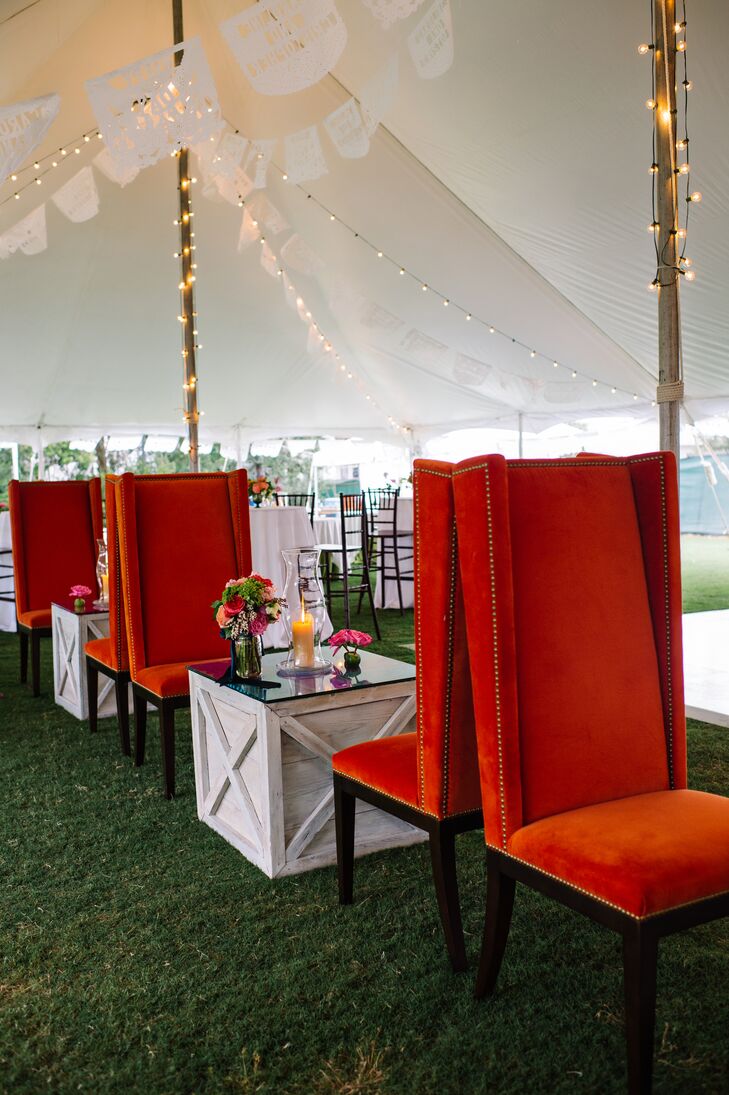 Guests had more than just their assigned chiavari chairs to lounge in during the reception. Caroline and Christopher set up a seating area with tall orange velvet chairs and wooden tables, so guests could chat and get a front-seat view of their friends on the dance floor.