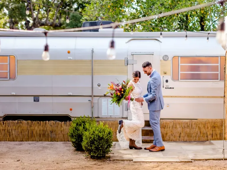 Couple standing in front of train at Springdale Station wedding venue in Austin, Texas