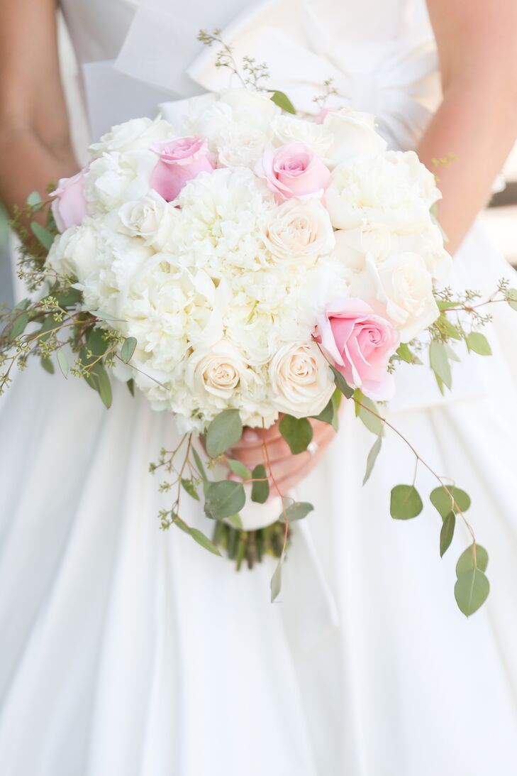 Lauren carried a classic arrangement of ivory and pink roses paired with eucalyptus leaves and wrapped in satin ribbon. "I tried to keep the flowers neutral, simple and classic," she says.