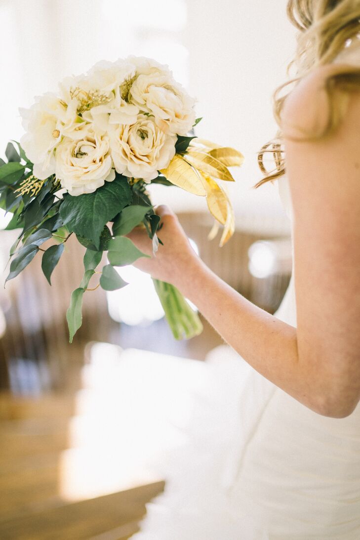 Elena used faux ivory-colored roses and eucalyptus leaves to create her bridal bouquet. The arrangements, including the groomsmen’s boutonnieres were made ahead of time and kept their fresh-looking appearance all day and night.