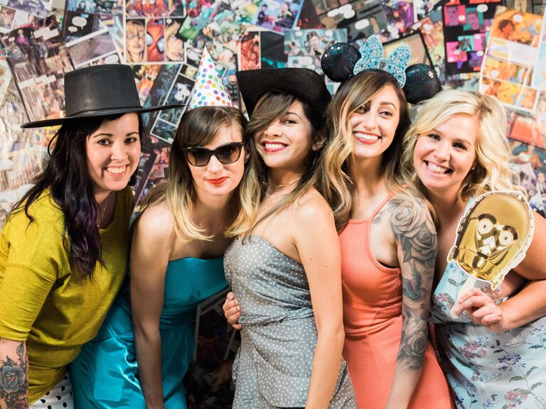Guests pose in front of custom comic book photo booth backdrop. 