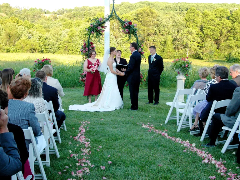 A couple tie the knot at an outdoor ceremony at Ladew Topiary Gardens in Monkton, Maryland