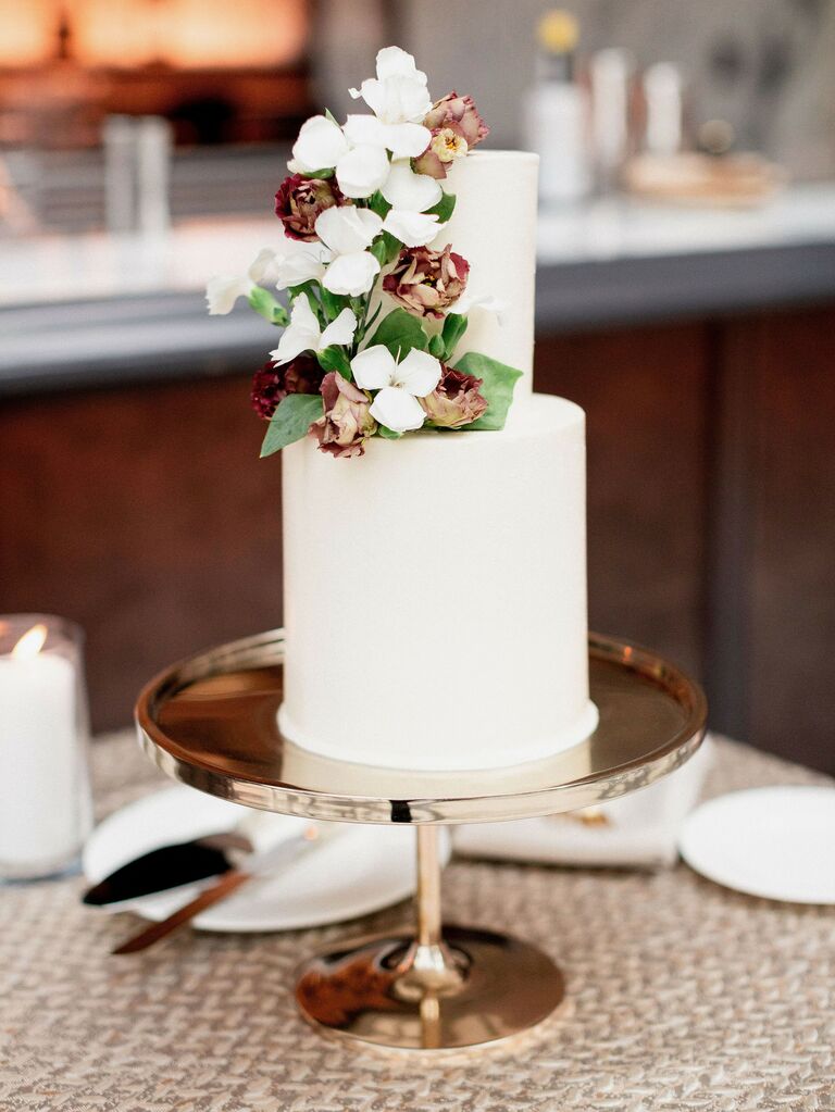 two-tier white fondant wedding cake on rose gold stand
