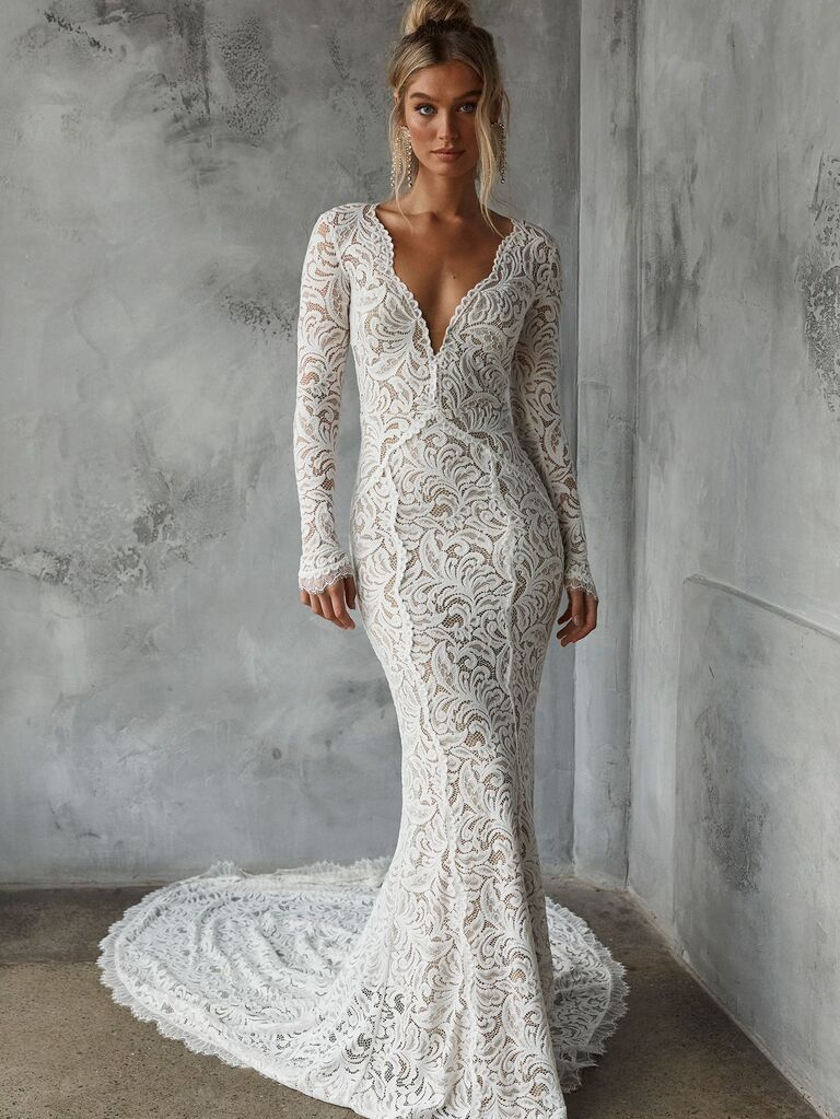 Model wears a mermaid-style lace wedding dress. 