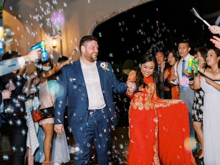 Bride and groom walk through bubbles for wedding exit. 
