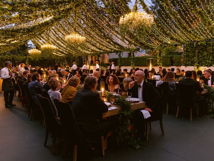 Wedding Guests Dining Under Canopy of String Lights