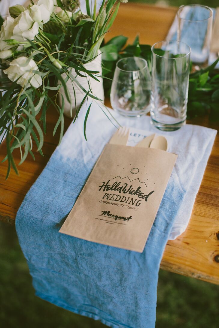 Guests found their seats by consulting customized brown paper bags that doubled as place cards. The bags featured the Erin and Tyler's wedding logo and each guest’s name, with a menu and compostable cutlery tucked inside. “It was a nice one-two punch,” Erin says.