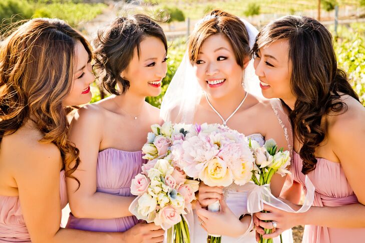 Joanne stood with her bridesmaids wearing pink and purple strapless dresses, and they all held pastel bouquets filled with peonies and roses.