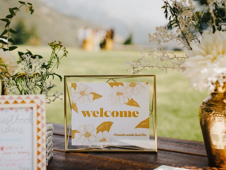 White and gold wedding welcome sign with couple's wedding hashtag