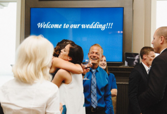 Bride and guests embracing at a surprise wedding