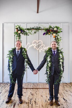 Grooms on Wedding Day Next to Custom Signage