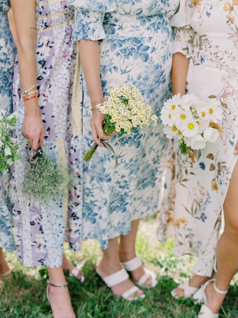 Bridesmaids wear light colored dresses with fun floral prints. 