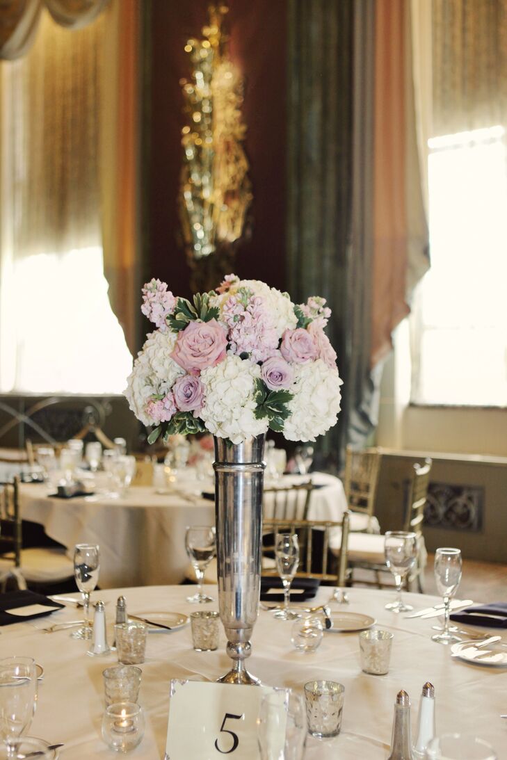 Some centerpieces featured tall silver vases filled with roses and hydrangeas.