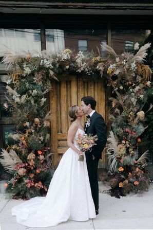 Couple Kissing in Front of Boho Dried-Flower Arch