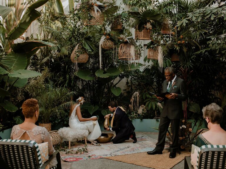 groom washes bride's feet during ceremony for christian foot washing ritual