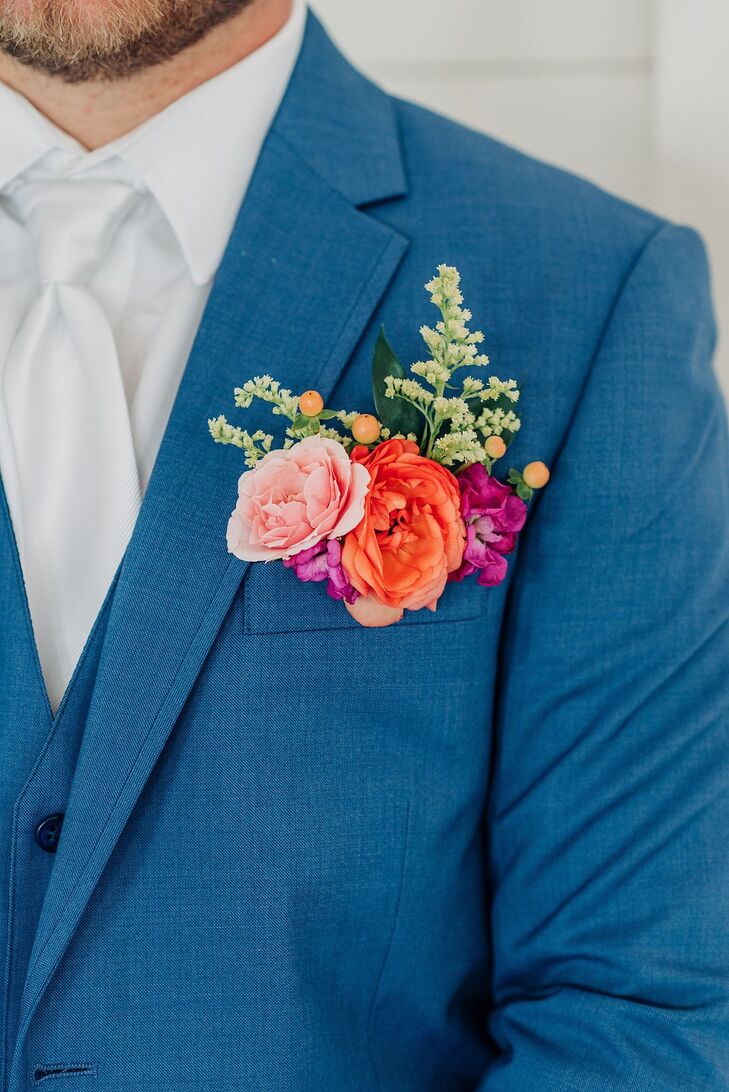 Groom in Blue Suit With Blush, Orange and Magenta Boutonniere and Greenery