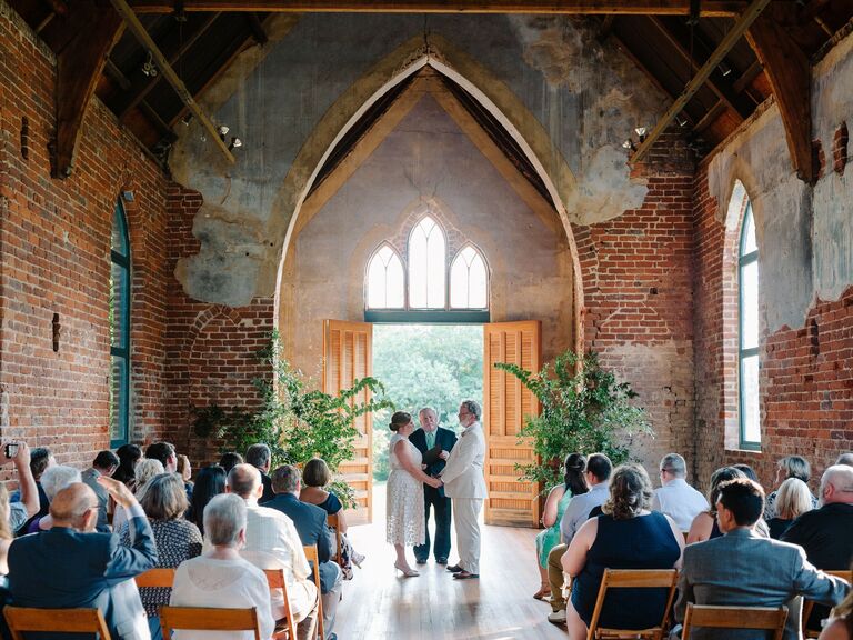brick chapel wedding venue with potted trees at altar