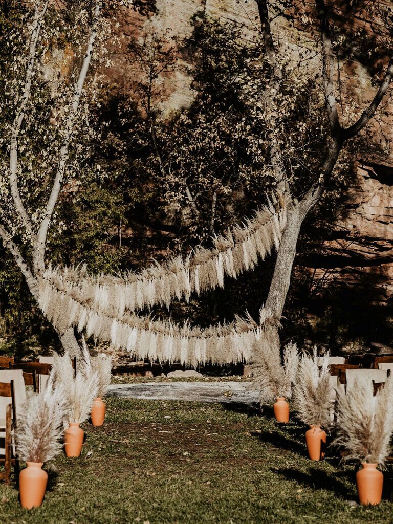 boho wedding arch alternative with pampas grass garlands strung between trees