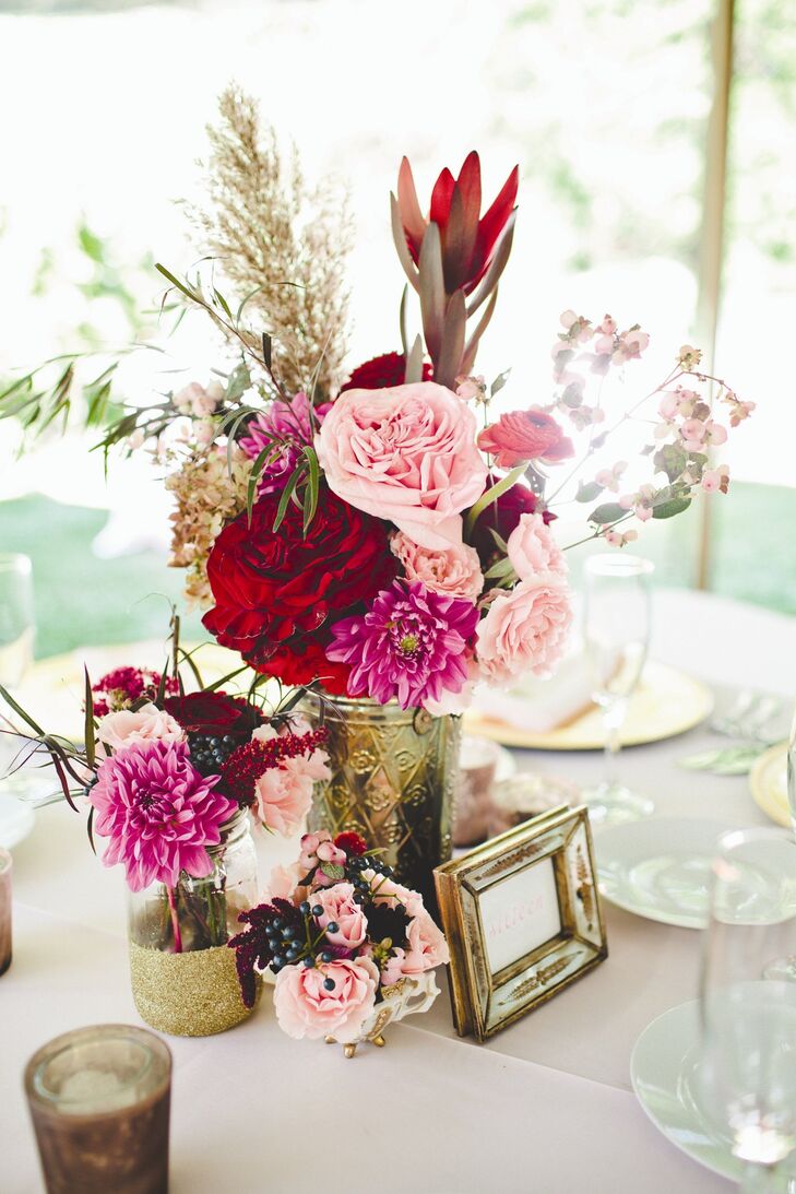 Clusters of vintage vases and mason jars filled with ivory, blush, red and burgundy blooms topped the reception tables.