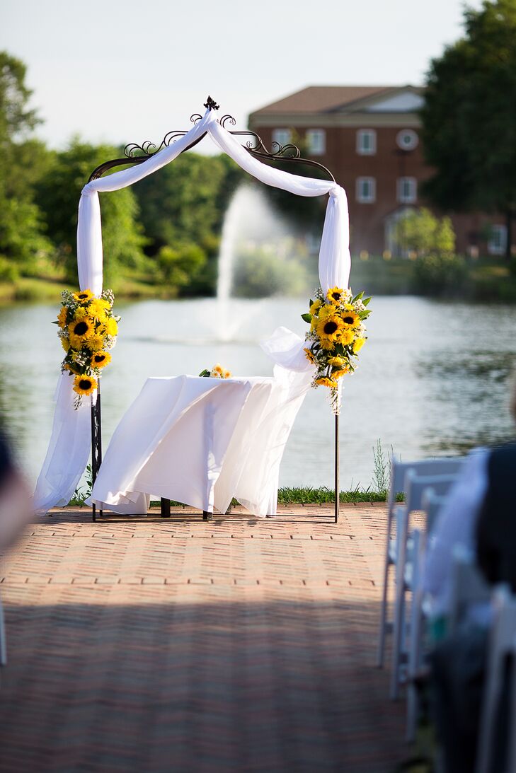 The waterside ceremony at Founders Inn was held under an arch draped with white linen and decorated with bouquets of sunflowers.