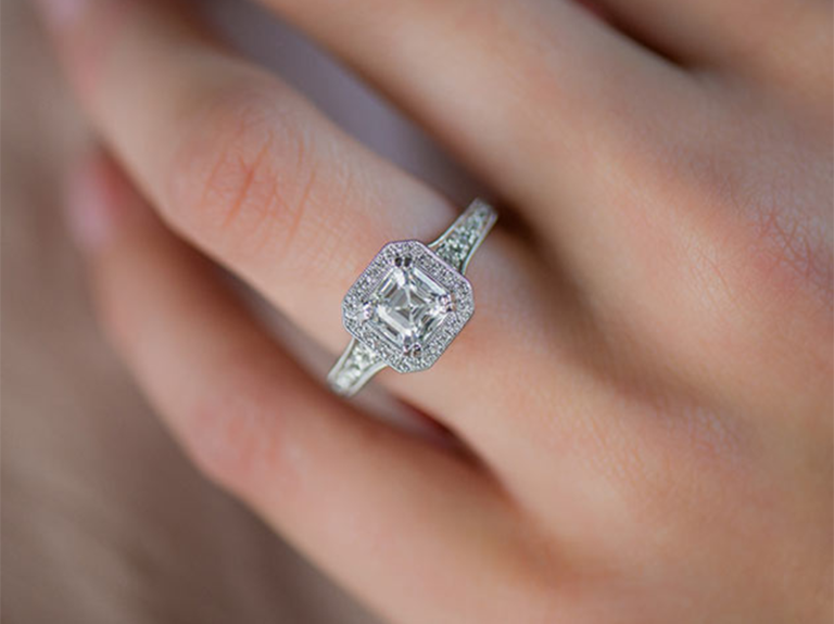 Asscher cut center diamond with halo on split white gold band with diamonds