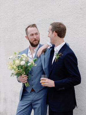 Groom in Blue Suit Holding Bouquet Posing Beside Partner