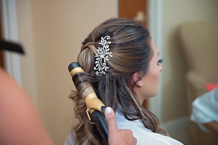 Mariel wore a glamorous sparkly crystal hair clip in her curled, half-down hairstyle. Her hair accessory perfectly complemented the David Tutera wedding dress, which she completed with a similar broach on a champagne belt.