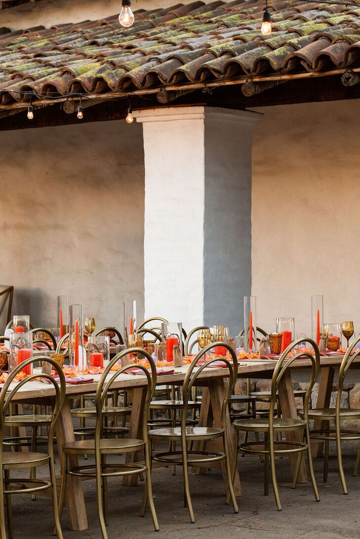 Long Wooden Reception Tables, Vibrant Orange Candles, Gold Metallic Chairs, Orange Petal Runner, Gold Goblets