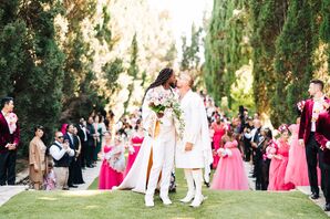 Grooms in Fashion-Forward, Custom Outfits Kiss at Outdoor Ceremony