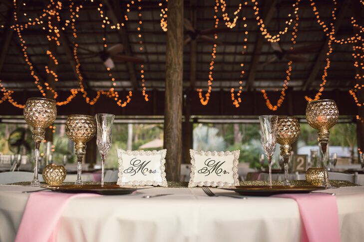 With a DIY number on every guest's table, Jami wanted to make sure their sweetheart table was just as personalized. She went to Hobby Lobby and picked out regal gold goblets as well as matching votives. Tealight candles filled each one. She also marked their seats with silver-framed “Mr.” and “Mrs.” frames.