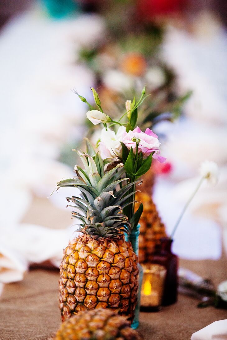 The ceremony aisle was lined with full pineapples along with small, simple flower arrangements. The middle of the aisle was sprinkled with petals and the natural sand.