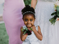 Flower girl smiling in her white flower girl outfit.