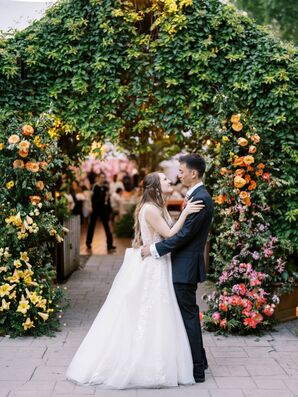 Couple Embraces Under Floral Arch and Greenery Tunnel, Enchanted Garden