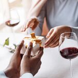Husband giving wife five-year anniversary gift at dinner 