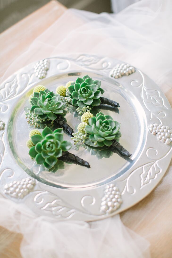 Robert's groomsmen wore deep green succulent boutonnieres accented with subtle yellow billy balls secured to their gray suits.