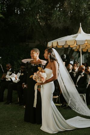 Bride's Mother in Black Gown With Bride in Sleek, Fitted Dress and Long Veil at Garden Altar