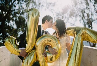 couple kissing and holding letter balloons