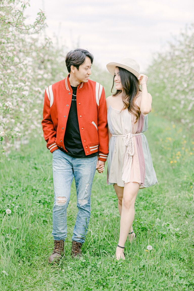 Couple walking through tree grove holding hands