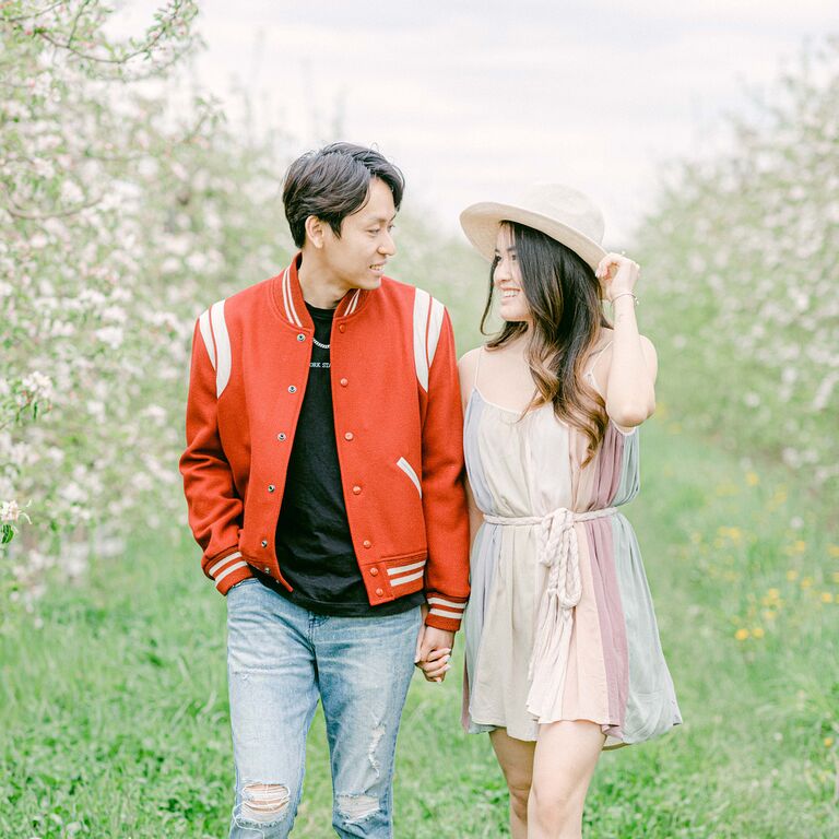 Couple walking through tree grove holding hands