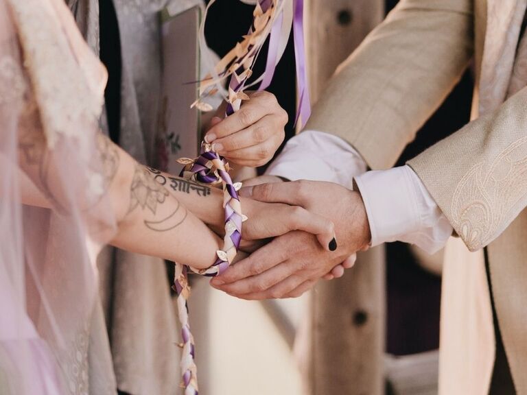 handfasting ceremony with purple ribbon
