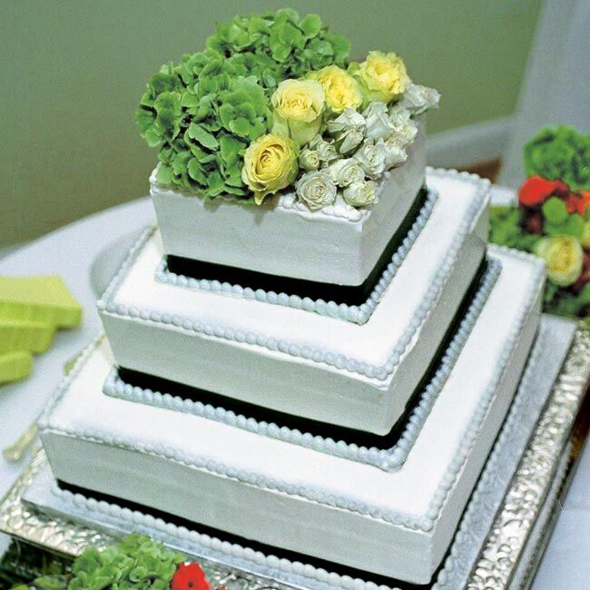 Diane and Scott’s cake was a four-tiered yellow cake covered with white buttercream frosting, wrapped with a green grosgrain ribbon, and topped with various green flowers. The groom’s cake was all chocolate and covered with chocolate shavings and strawberries.