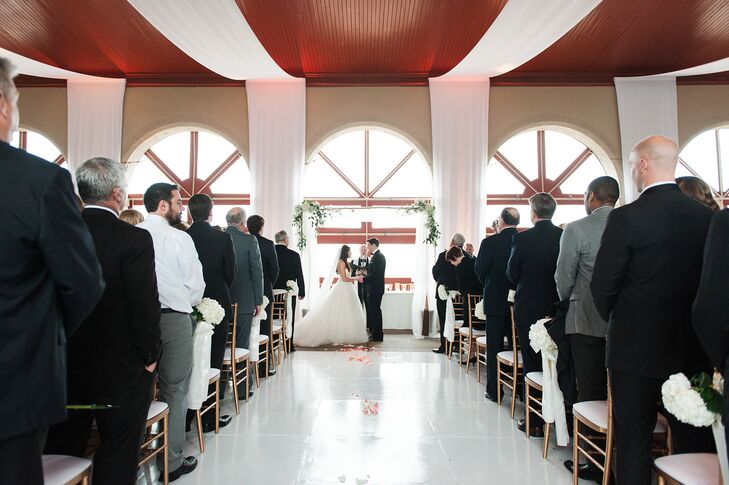 Kathleen and Alan planned to exchange vows outside, but they had to move inside because of the weather. They decorated the venue with white drapery on the ceiling to create a more intimate, chic aura. The linens were lit with a warm candlelight hue that got brighter as the night progressed.