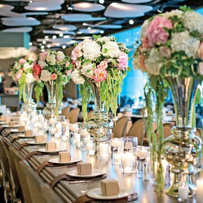Mercury glass candleholders, flowers that echoed the bridesmaid bouquets (with ranunculus and garden roses) and neutral linens set an organic tone.The table numbers were a black-and-white Vera Wang stationery set I finished with a reclaimed-wood look, Tiffany says.