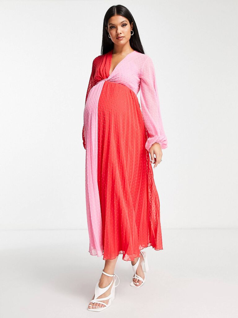 Model wears pink and red pleated maxi dress. 